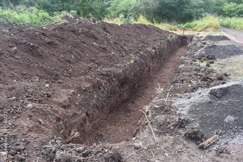 Digging a trench. Earthworks, digging trench. Long earthen trench dug to lay pipe, cable or optical fiber.