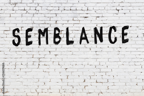 White wall with black paint inscription semblance on it
