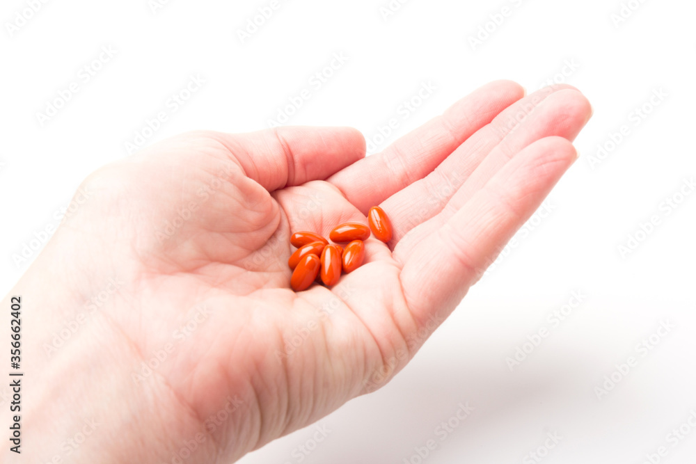 Coenzyme q10 supplement capsules in hand close-up on white background Coenzyme q10 supplement capsules in hand close-up on white background