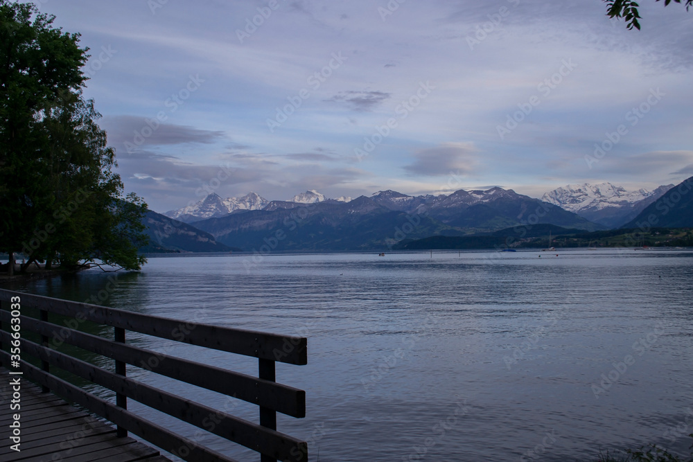 view from the lake to the bridge and mountains in Switzerland in the evening