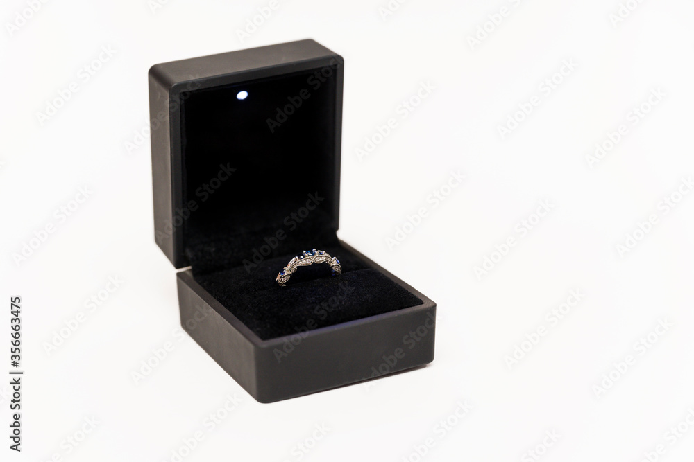 Engagement ring with blue stones in a black box. Engagement ring with blue stones in a black box.