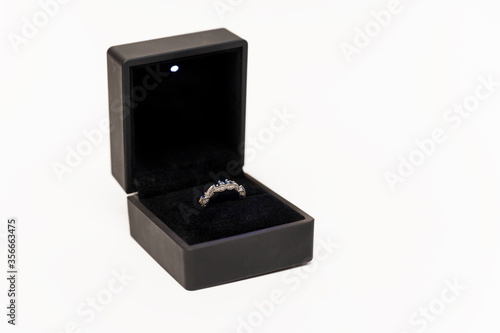 Engagement ring with blue stones in a black box.