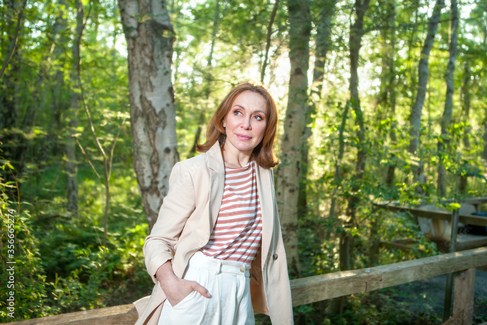A beautiful woman posing on a wooden bridge in a Park A beautiful woman posing on a wooden bridge in a Park