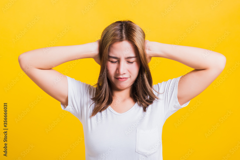 Asian Thai happy portrait beautiful cute young woman smile have closed palms ears with palms and close eyes, studio shot isolated on yellow background with copy space Asian Thai happy portrait beautiful cute young woman smile have closed palms ears with palms and close eyes, studio shot isolated on yellow background with copy space
