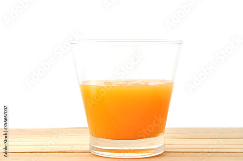 glass of orange juice on wood table