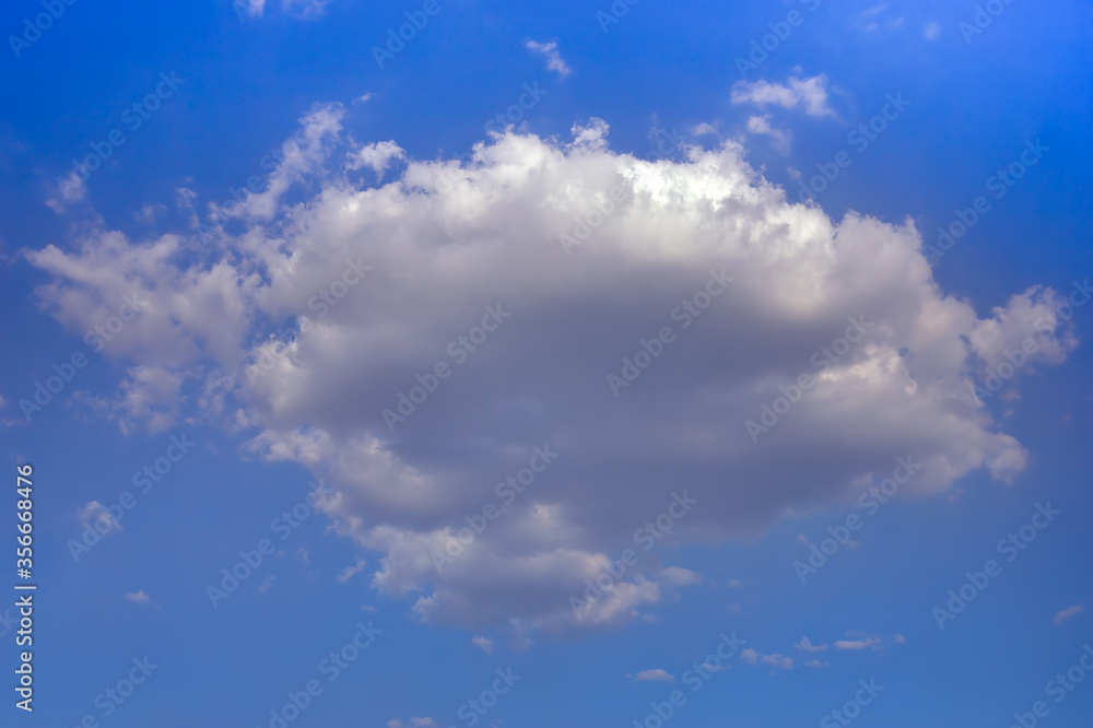 Fototapeta premium Lonely white cumulus cloud in a blue spring sky. Nature background.