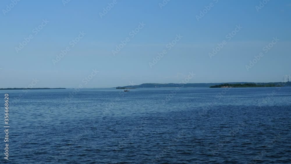 in the distance a boat on a wide river or lake in the distance a boat on a wide river or lake