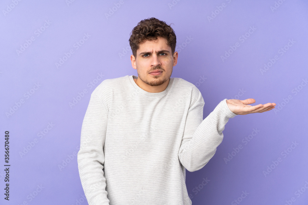 Caucasian man isolated on purple background having doubts