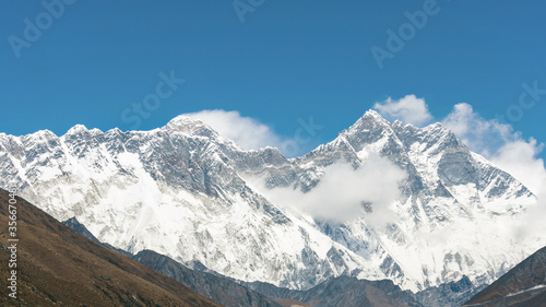 View of Mount Everest and Lhotse with clouds near the summit and a clear blue sky from Tengboche during Everest Base Camp trek  Sagarmatha  Nepal
