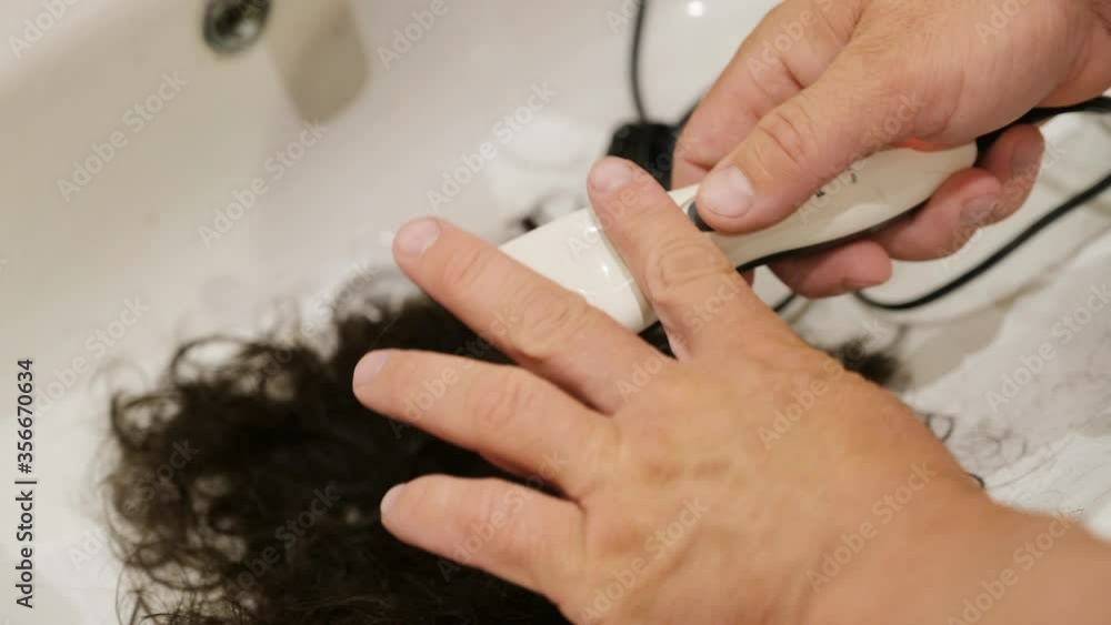 A man's hand cleans a hair cutter. closeup. A man's hand cleans a hair cutter. closeup.