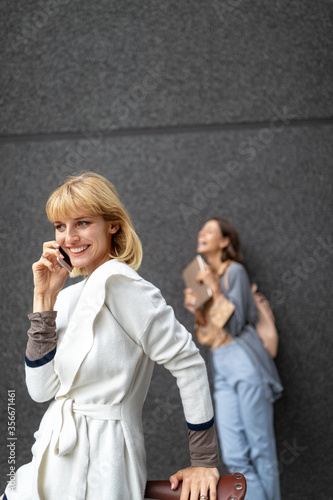 Portrait of a smiling beautiful woman with phone, smartphone outdoor