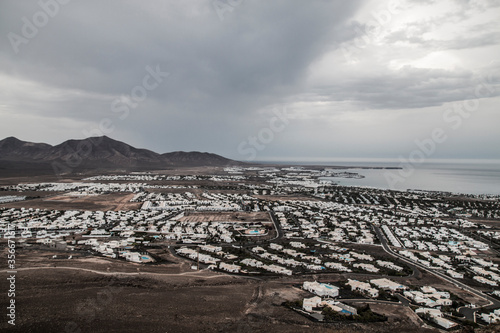  panoramic view of Volcano Montana Roja de Playa Blanca, Lanzarote, Spain. One of the most popular volcano in Canary Islands and the total view of the village in the south with white houses. 