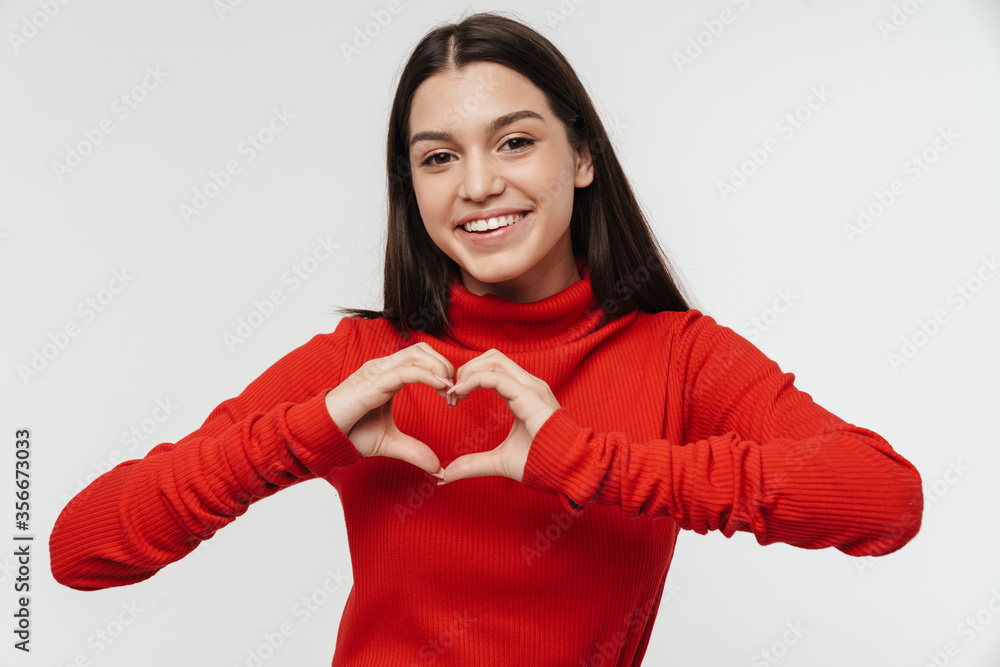 Photo of happy young woman smiling and showing heart with fingers Photo of happy young woman smiling and showing heart with fingers