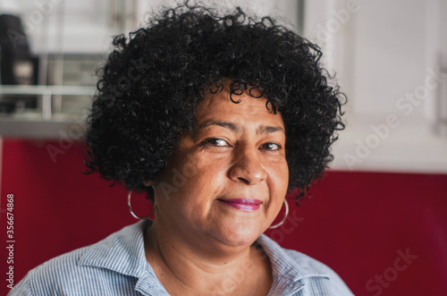 portrait dominican adult woman with dark skin with curly hair with white background for enrollment © Julaix