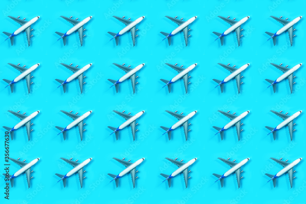 Pattern made of model airplane on blue background.