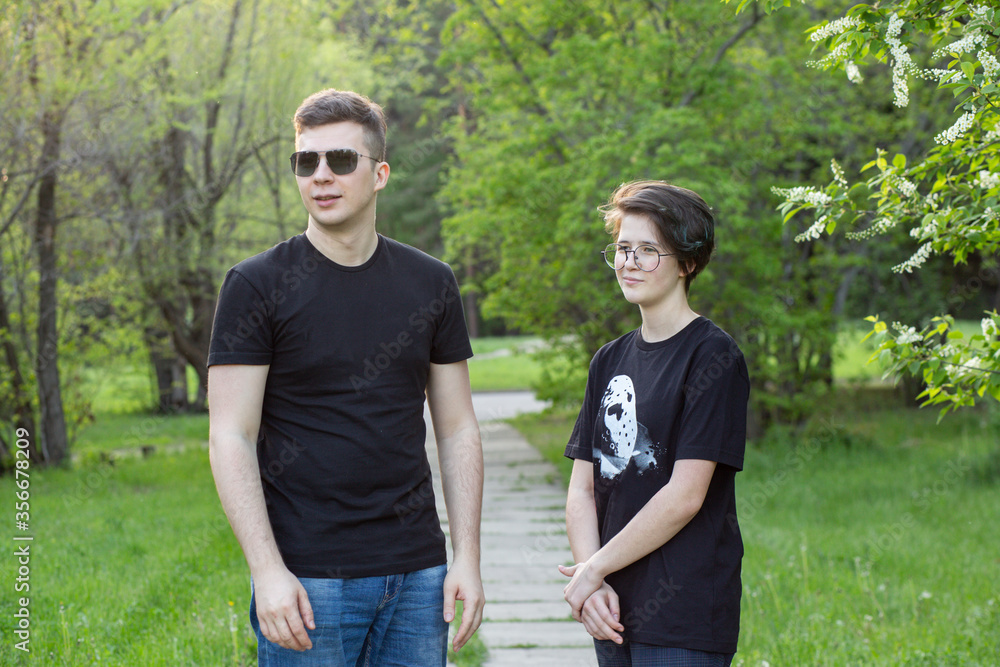 Obraz premium A guy and a girl walk and chat in the park.