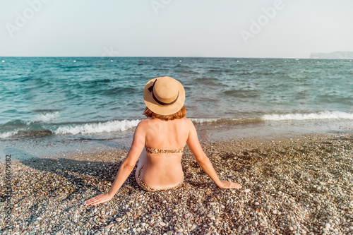 Young women in the hat on the beach
