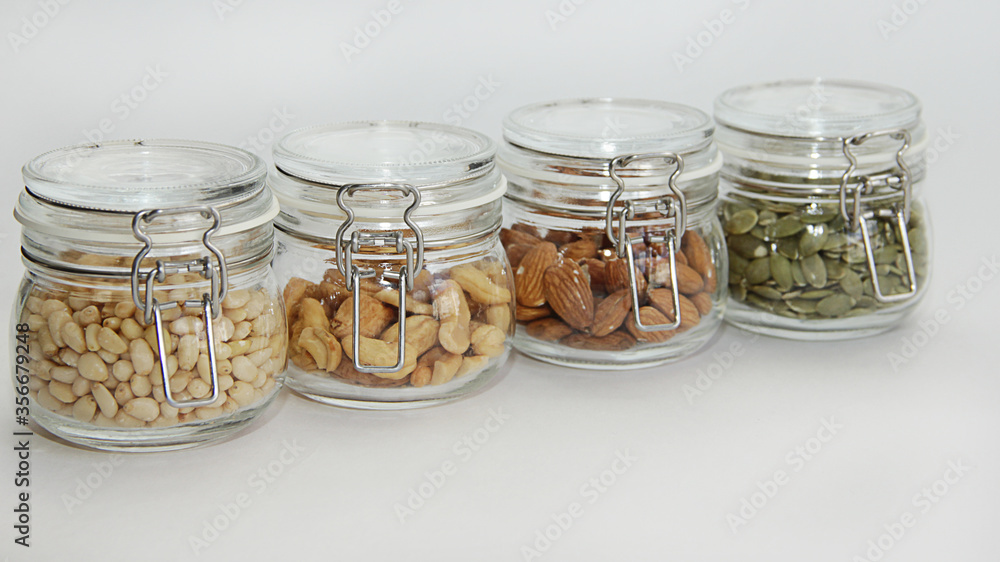 glass jars with nuts on a white background glass jars with nuts on a white background