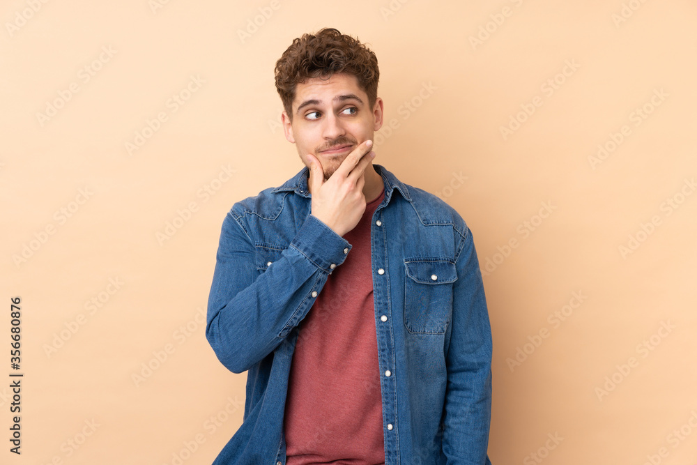 Caucasian man isolated on beige background thinking an idea Caucasian man isolated on beige background thinking an idea