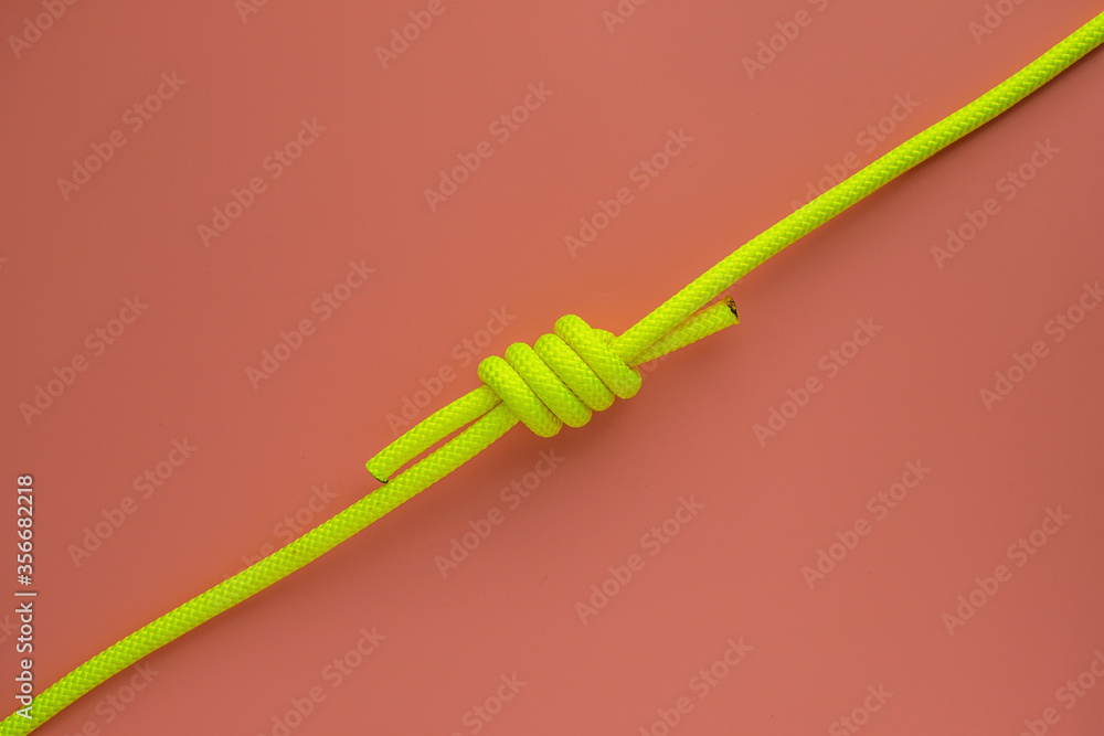 The green rope lies on a pink background The green rope lies on a pink background
