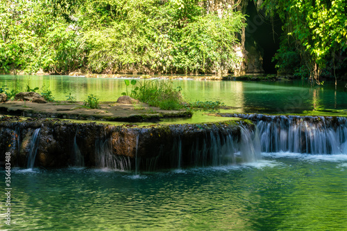 Waterfall in deep tropical rain forest green tree