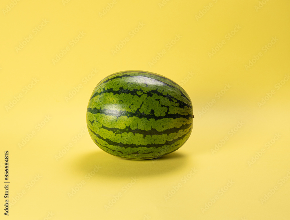 green watermelon on yellow background green watermelon on yellow background