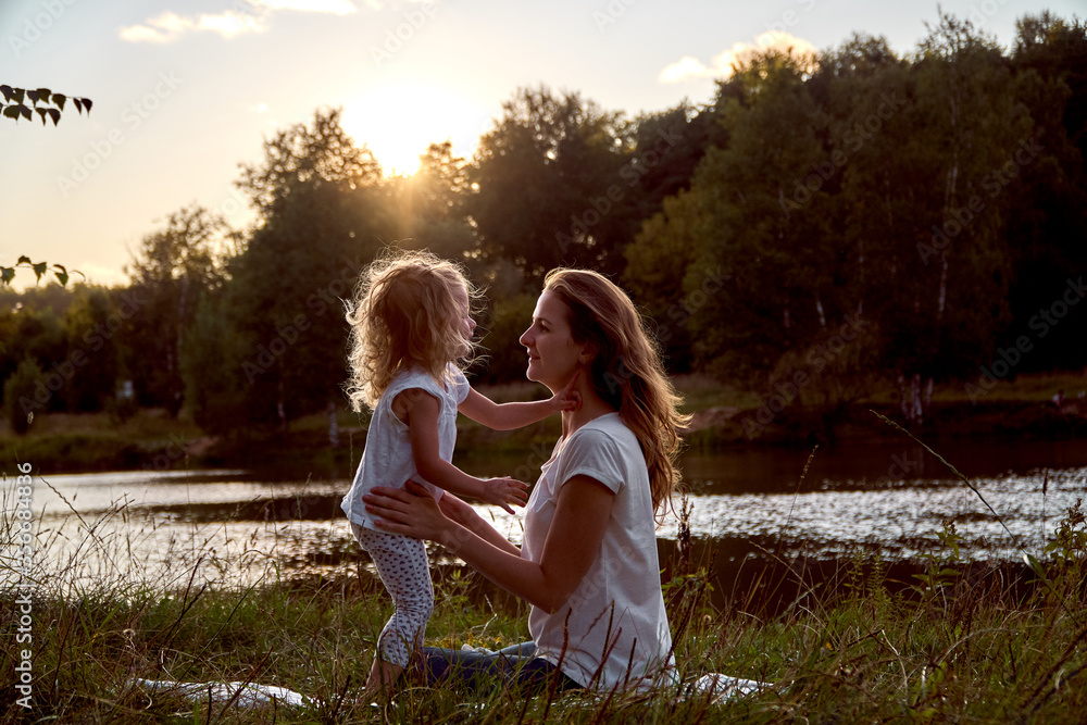 Fototapeta premium Daughter and mom are hands together. The family is happy. Smiles and laughter. They look at each other.