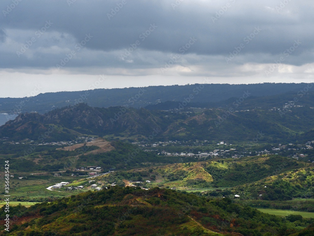 Medium close up of the eastern side of Barbados in the Caribbean Islands, with houses spread out beyond the valleys and hills