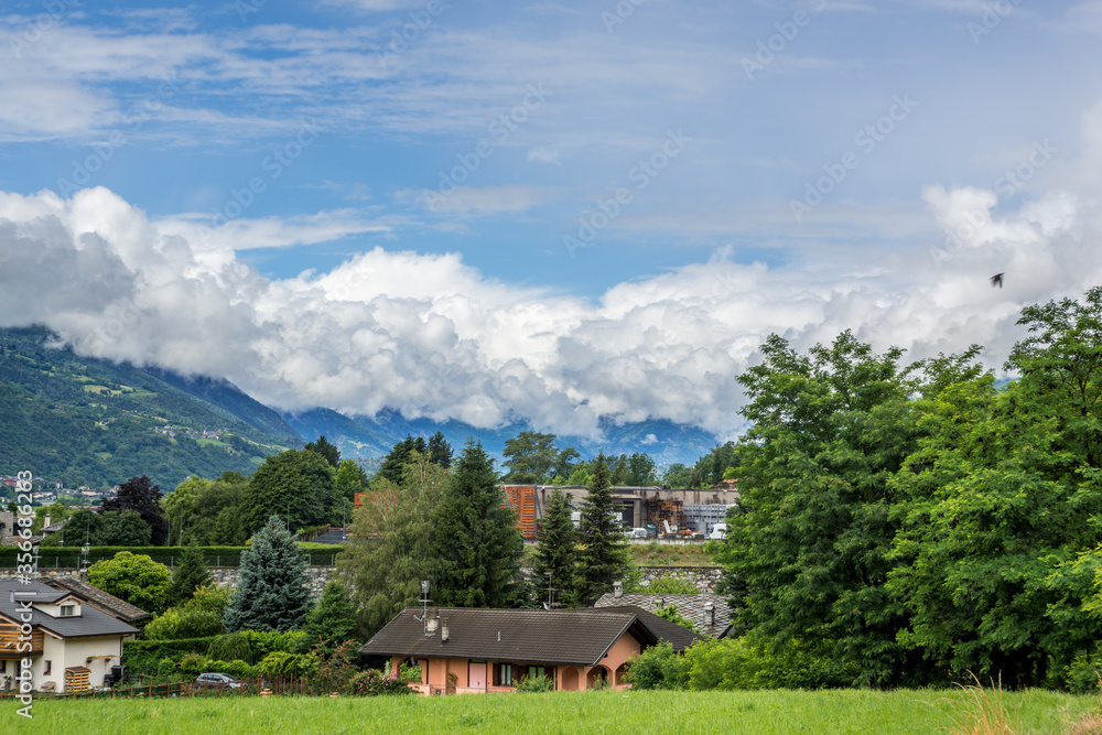 mountain panorama in spring with cloudy sky and play of light in the mountains
