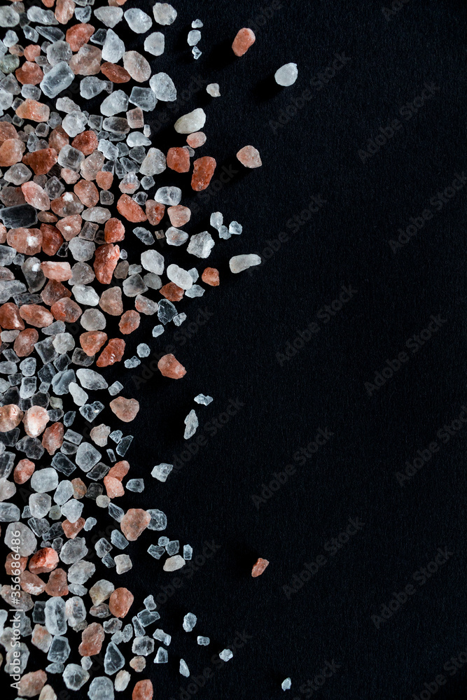 Pink himalayan crystal salt on black background. Handful of salt. Vertical background wallpapers. Beautiful rock salt crystals on dark background Pink himalayan crystal salt on black background. Handful of salt. Vertical background wallpapers. Beautiful rock salt crystals on dark background