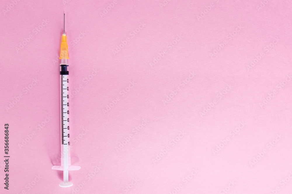 Top view syringe on pink background for coronavirus prevention. Covid-19 kit. Copy Space. Medical concept. Top view syringe on pink background for coronavirus prevention. Covid-19 kit. Copy Space. Medical concept.