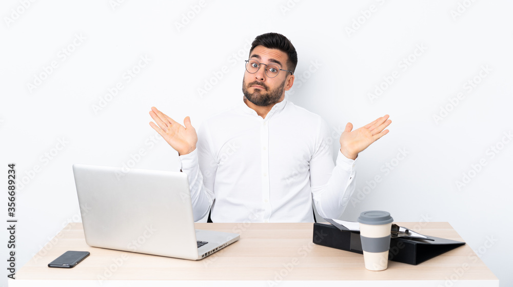Young businessman in a workplace making doubts gesture Young businessman in a workplace making doubts gesture