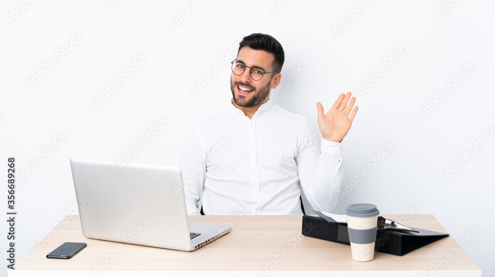 Young businessman in a workplace saluting with hand with happy expression Young businessman in a workplace saluting with hand with happy expression