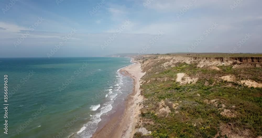 Tropical beach video, aerial bird eye view of blue foaming ocean waves crushing against the coast line in Veselovka (Russian: Веселовка) is a rural locality (a village) in Krasnodar territory, Russia. Tropical beach video, aerial bird eye view of blue foaming ocean waves crushing against the coast line in Veselovka (Russian: Веселовка) is a rural locality (a village) in Krasnodar territory, Russia.