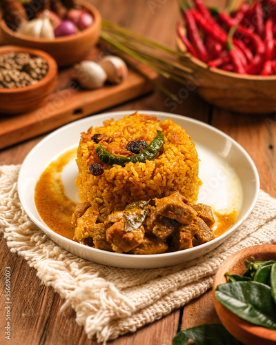 Indian Mutton Biryani Dish served on wooden table. Typical food from India, made from goat meat mixed with spices and basmati rice photo