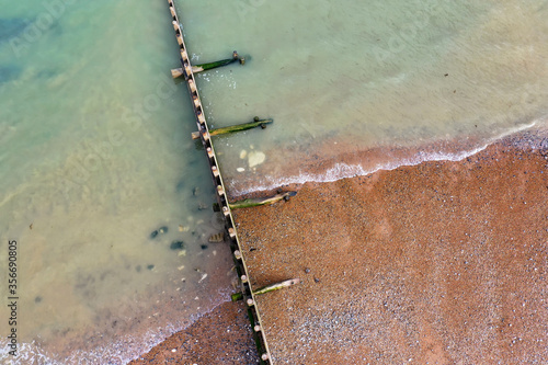 beach aerial view with groin and waves lapping the shoreline, taken in Eastbourne, East Sussex