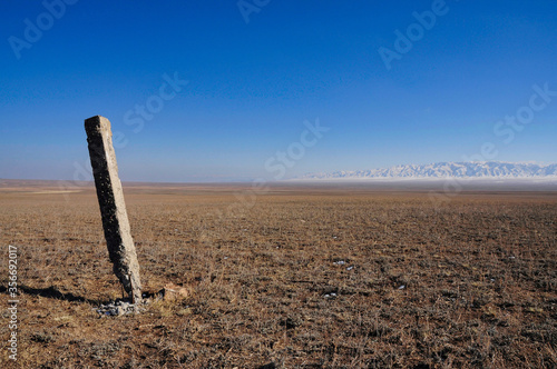 View across the vast Kazakh steppe towards some snow covered hills.