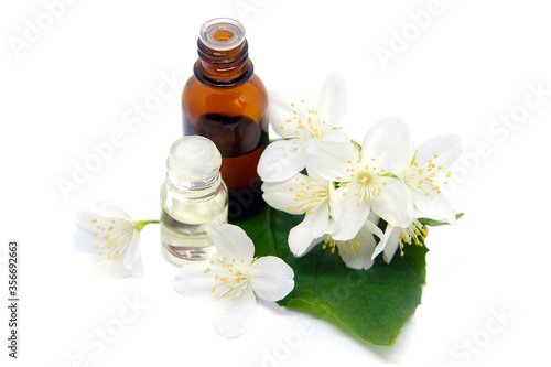 Essential aroma oil with jasmine on white background.