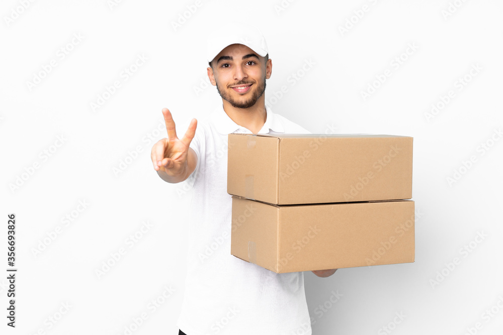 Delivery Arabian man isolated on blue background smiling and showing victory sign Delivery Arabian man isolated on blue background smiling and showing victory sign