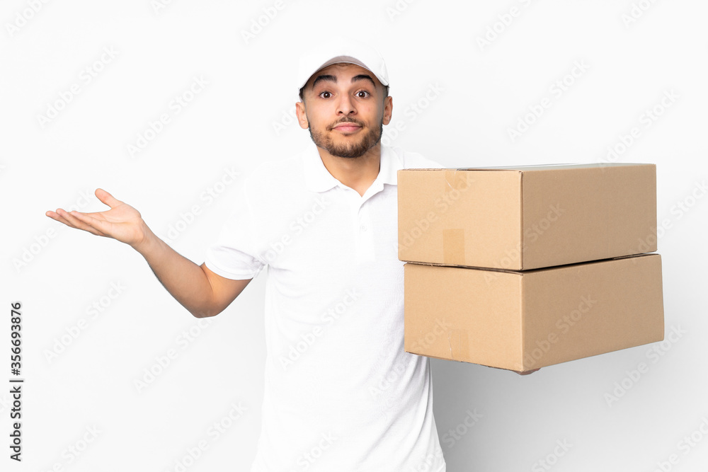 Delivery Arabian man isolated on blue background having doubts with confuse face expression Delivery Arabian man isolated on blue background having doubts with confuse face expression
