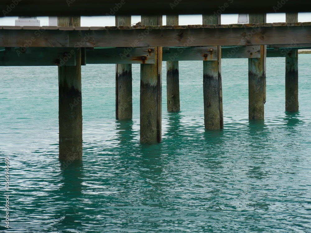 Wooden planks support a platform serving as a dock to visiting boats in one of the islands in the Exuma Cays in the Bahamas