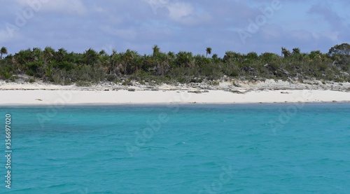 A stunningly white sandy beachline gives perfect contrast to the blue waters of the Exuma Cays in the Bahamas.