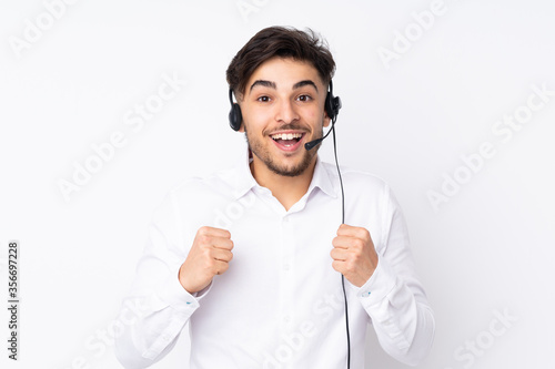 Telemarketer Arabian man working with a headset isolated on white background celebrating a victory