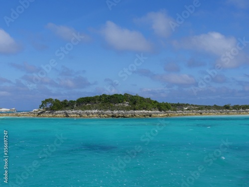 Fototapeta Naklejka Na Ścianę i Meble -  Rocky island covered in greens dotting the vast blue ocean of Bahamas in the Exuma Cays.