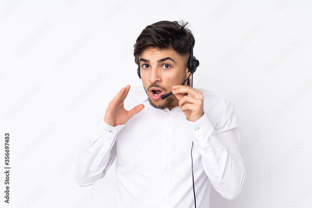 Telemarketer Arabian man working with a headset isolated on white background whispering something