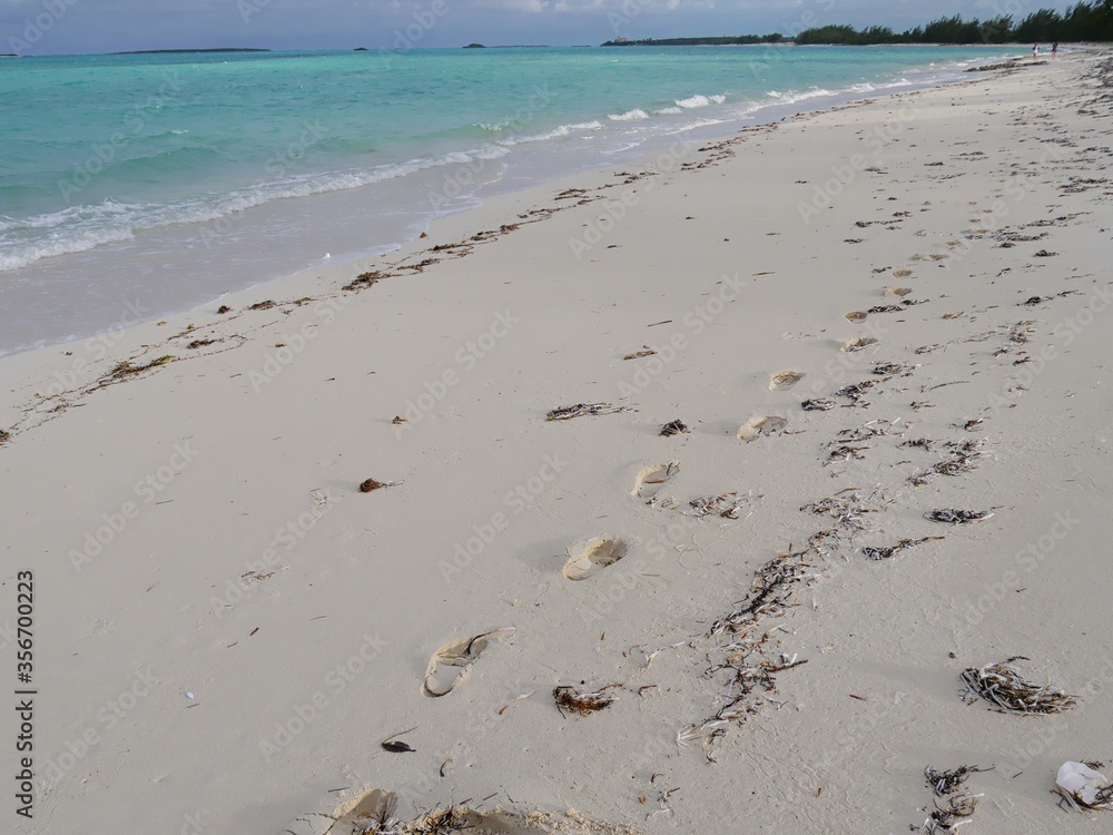 Wide shot of a beautiful pristine beach with footprints in the sand Wide shot of a beautiful pristine beach with footprints in the sand