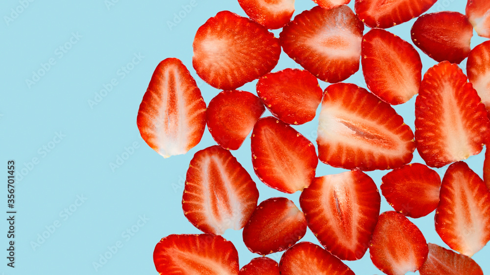 Texture of sliced strawberries on a bright blue background. Bright natural abstract wallpaper made of food. Texture of sliced strawberries on a bright blue background. Bright natural abstract wallpaper made of food.
