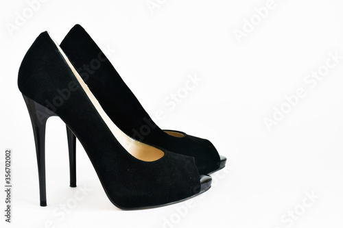 Black suede women shoes with high heels on a white background. Place for text.