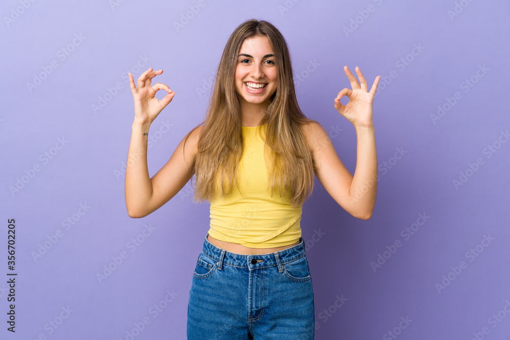 Young woman over isolated purple background showing ok sign with two hands Young woman over isolated purple background showing ok sign with two hands