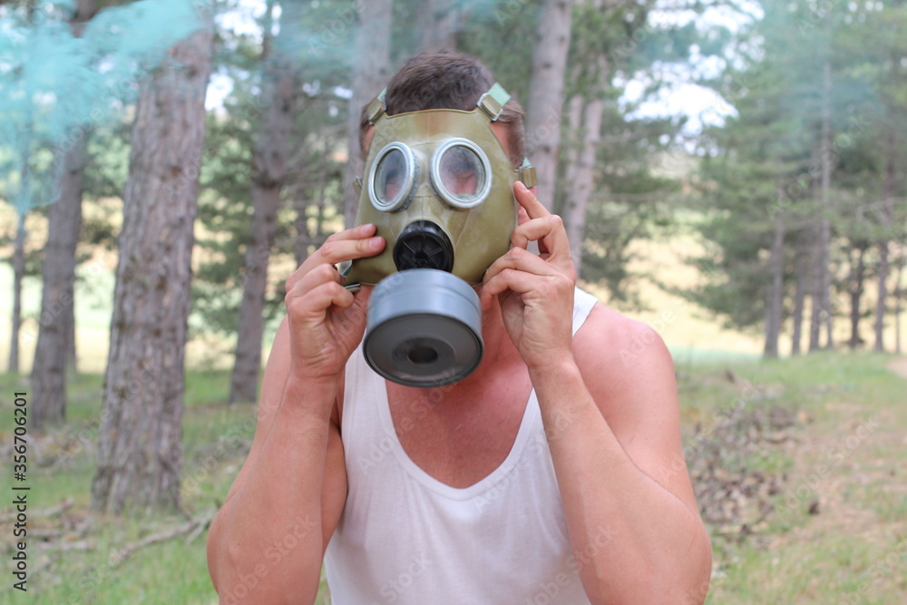 Man removing gas mask in the forest
Man removing gas mask in the forest